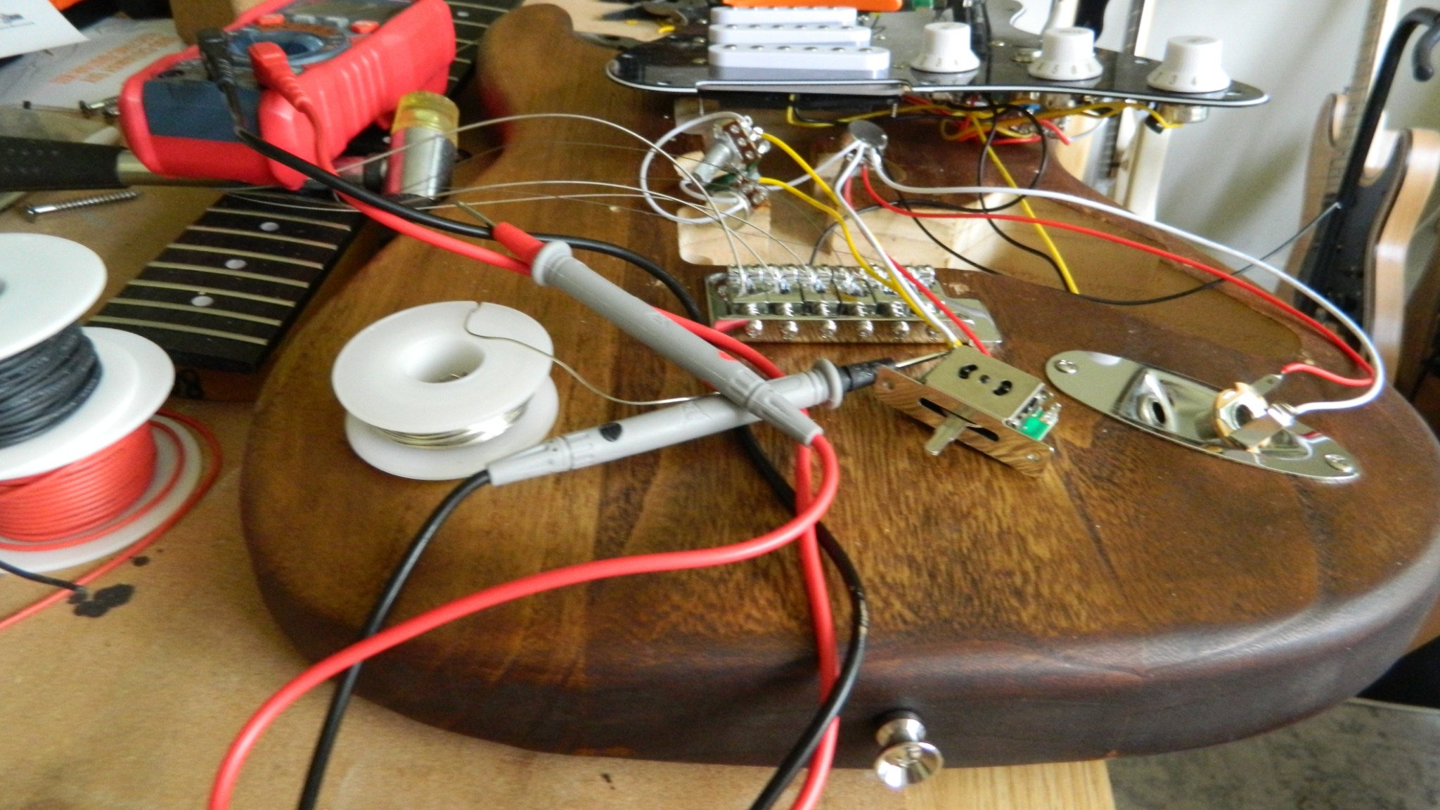 Electric guitar electronics and components on a workbench